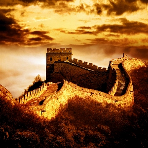 Scenic view of the Great Wall of China winding through lush green mountains under a blue sky
