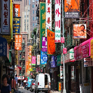 Vibrant street scene in Chinatown, New York, with busy shops, colorful signs, and pedestrians enjoying the lively atmosphere