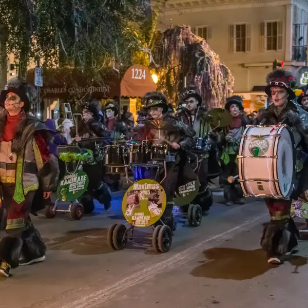 Group of people celebrating Mardi Gras in New Orleans with colorful costumes and masks