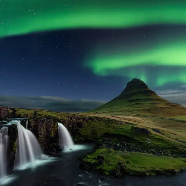 Stunning view of the northern lights dancing in the sky above the majestic Kirkjufell mountain in Iceland